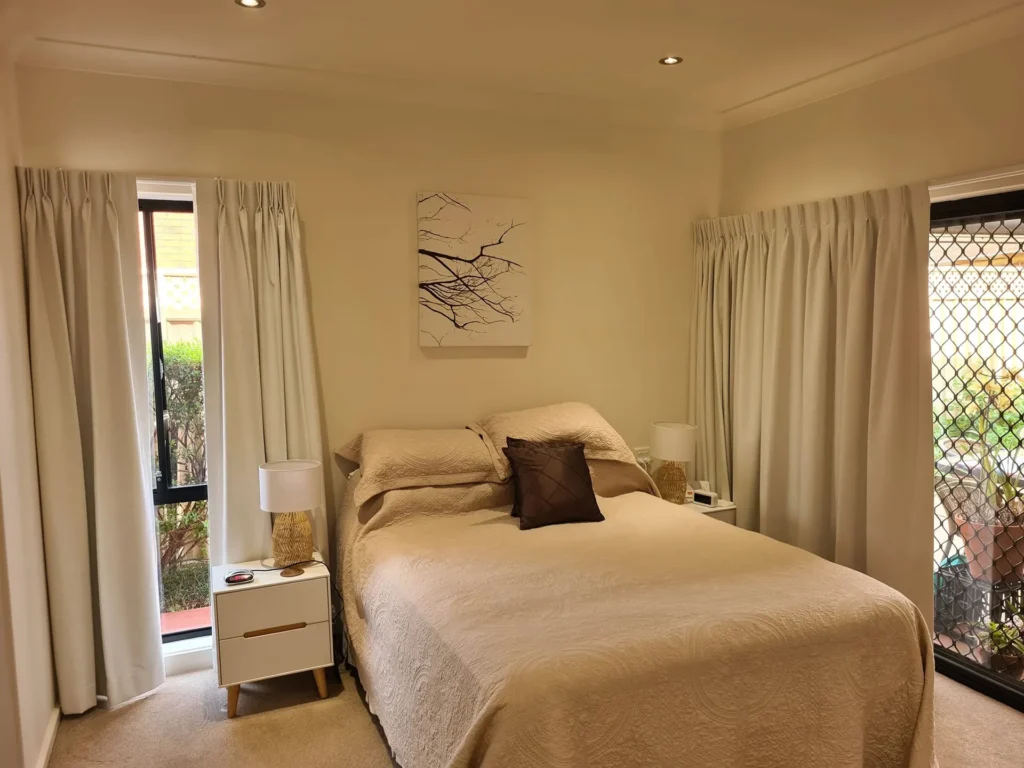 Pinch pleat curtains on both windows in a bedroom in Glenn Valley, NSW